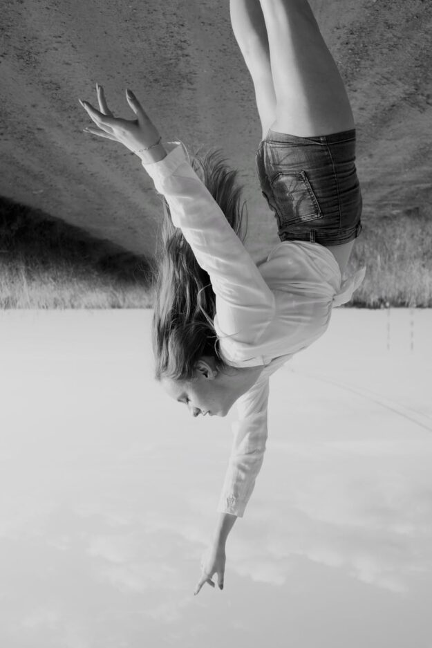 a woman reaching up in upside down photo