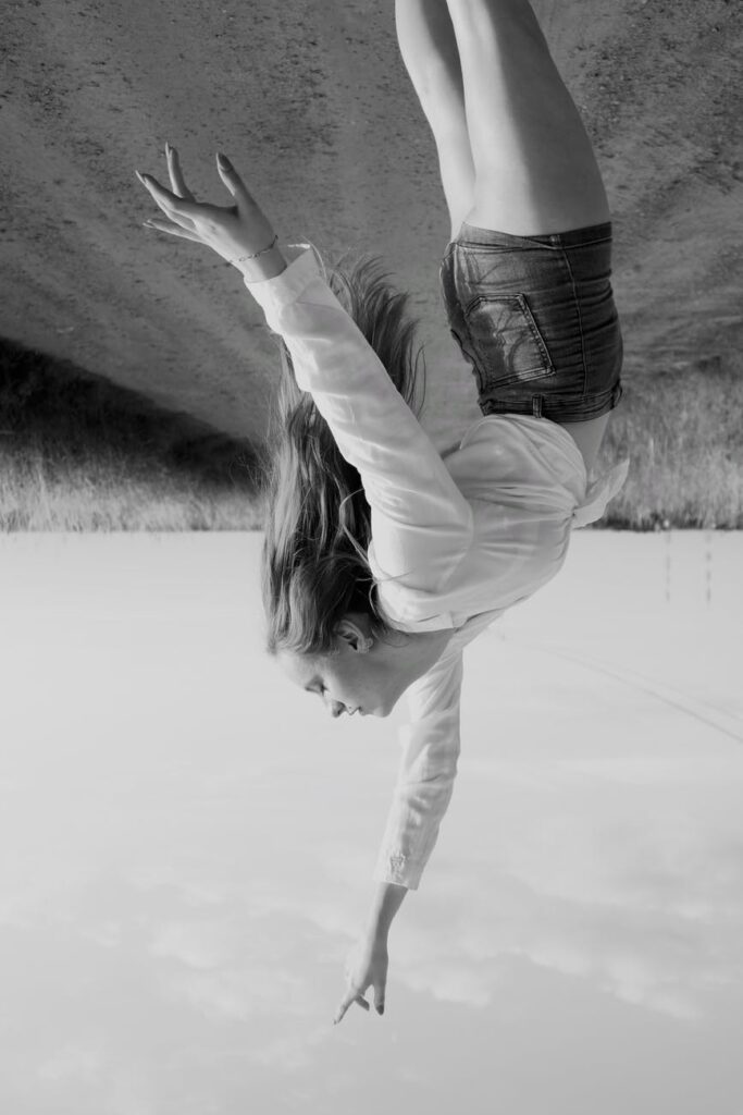 a woman reaching up in upside down photo