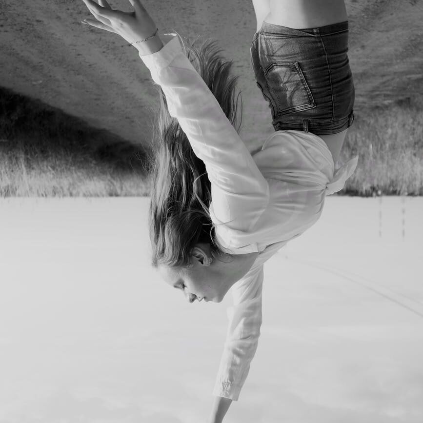 a woman reaching up in upside down photo